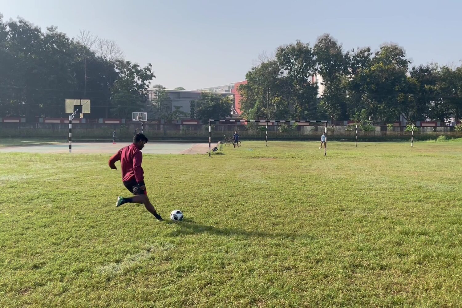 Me kicking a soccer ball on a grass field